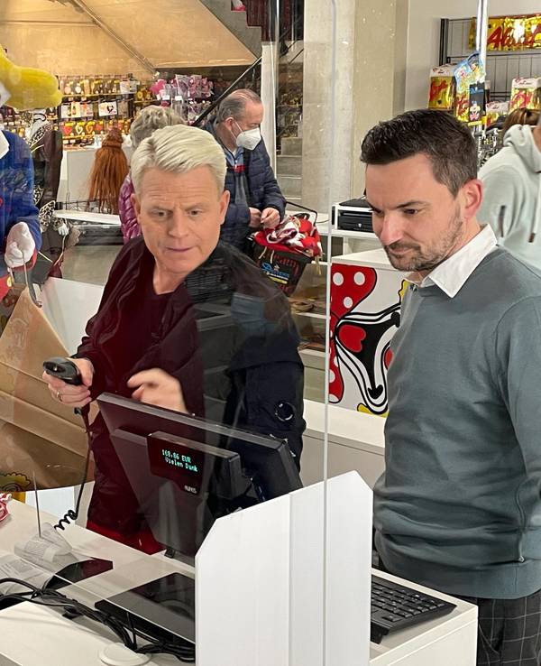 Fernsehstar Guido Cantz und Deiters-Geschäftsführer Björn Lindert bei der Arbeit an der Kasse.