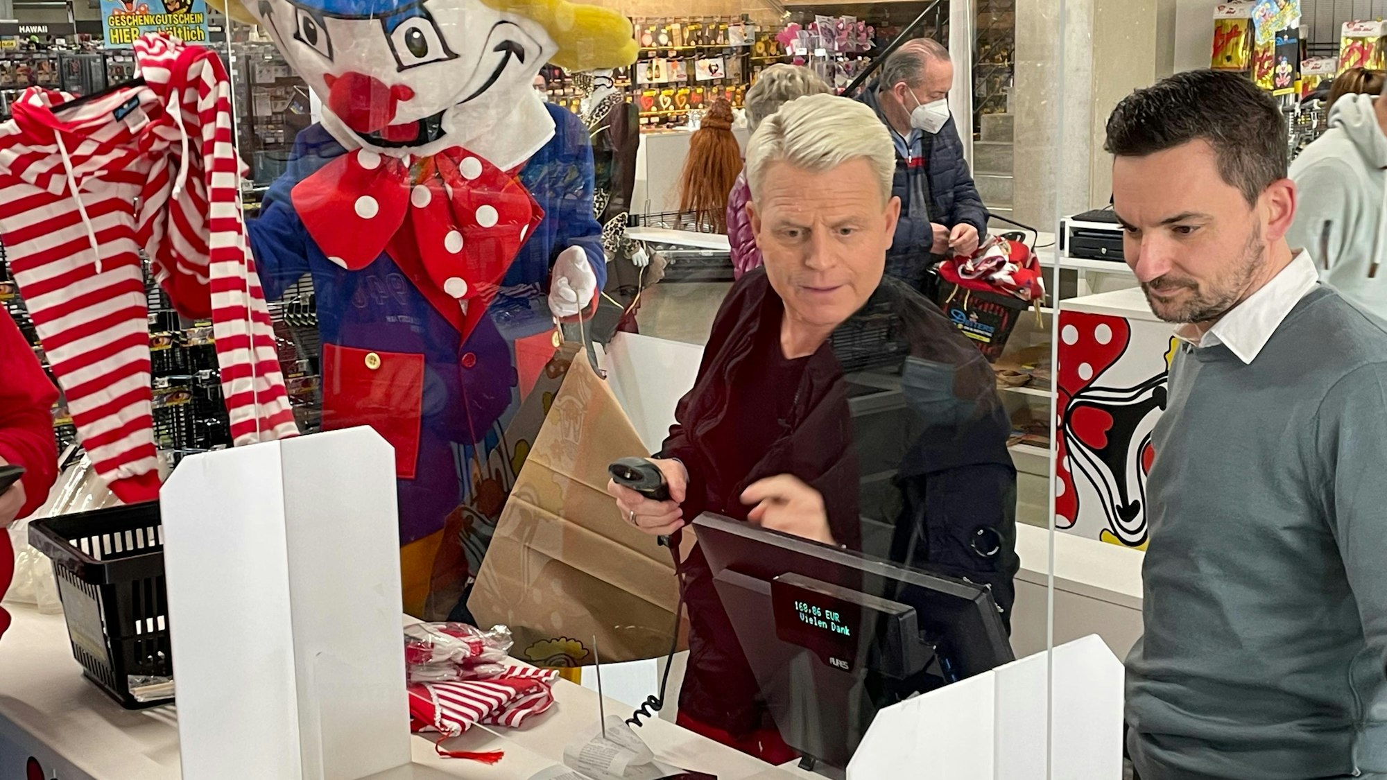 Fernsehstar Guido Cantz und Deiters-Geschäftsführer Björn Lindert bei der Arbeit an der Kasse.