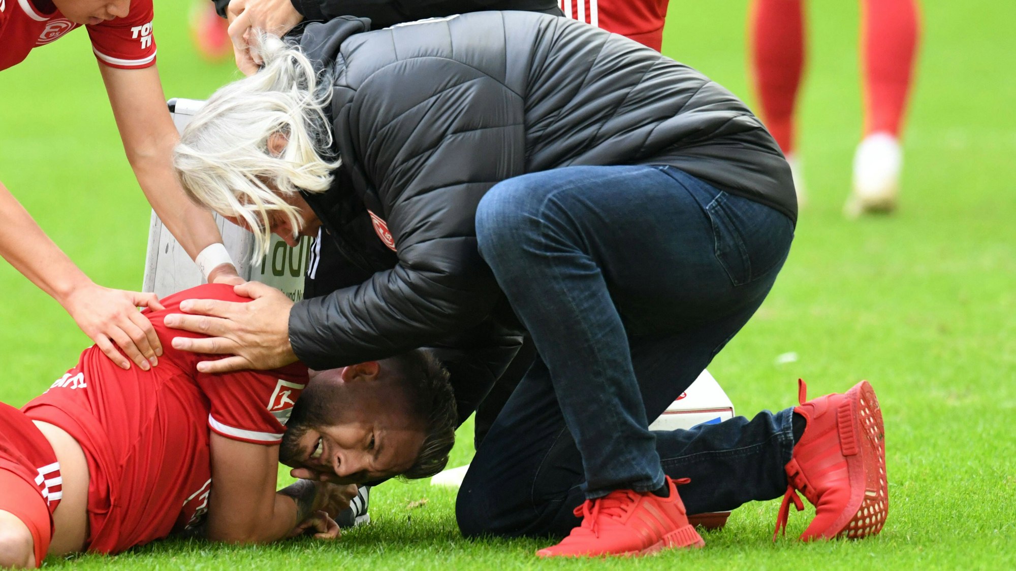 Der Mannschaftsarzt von Fortuna Düsseldorf, Dr. Ulf Blecker, kümmert sich um den verletzten Andre Hoffmann.