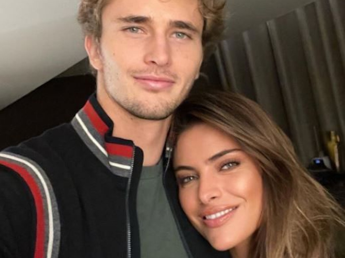 Alexander Zverev und Sophia Thomalla blicken in die Kamera und lächeln. Sie legt ihren Kopf auf seine Brust.