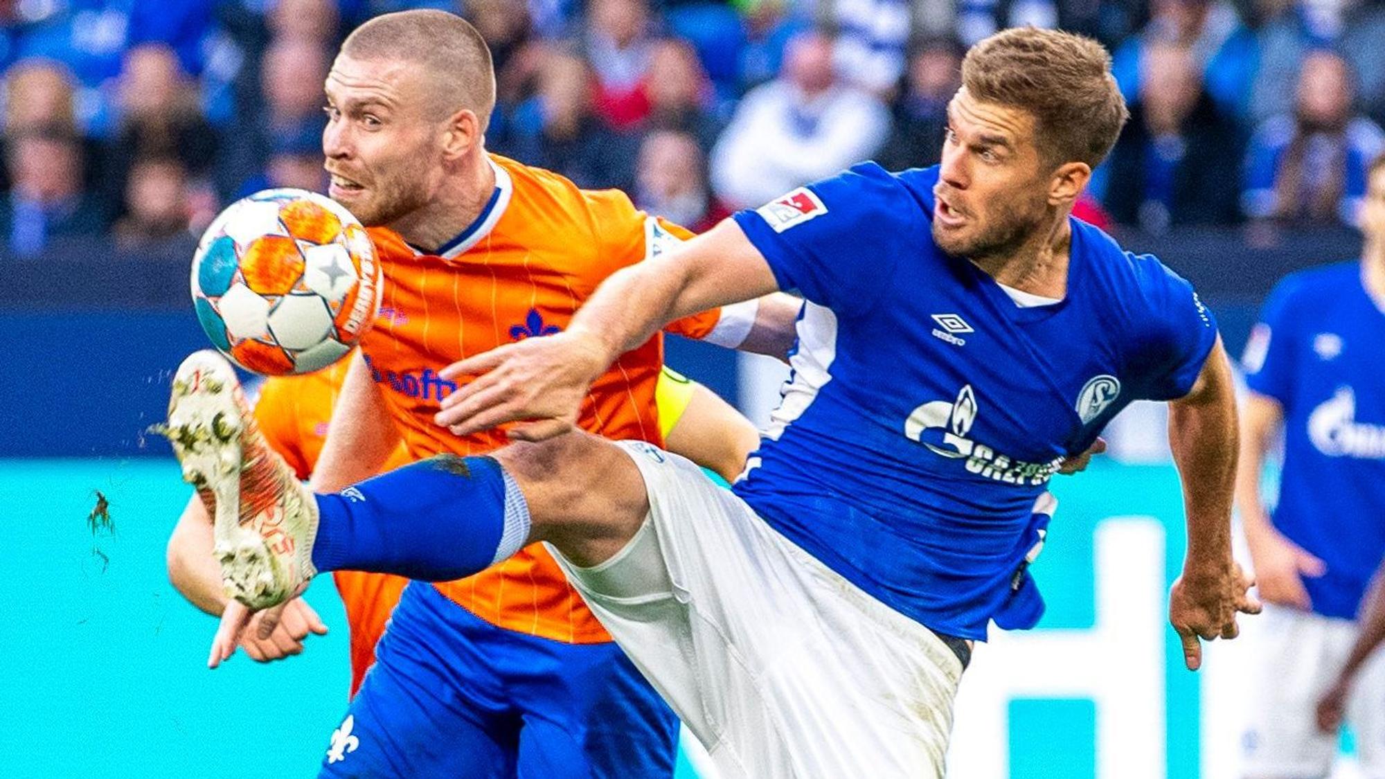 Darmstadts Thomas Isherwood (l) und Schalkes Simon Terodde kämpfen um den Ball.