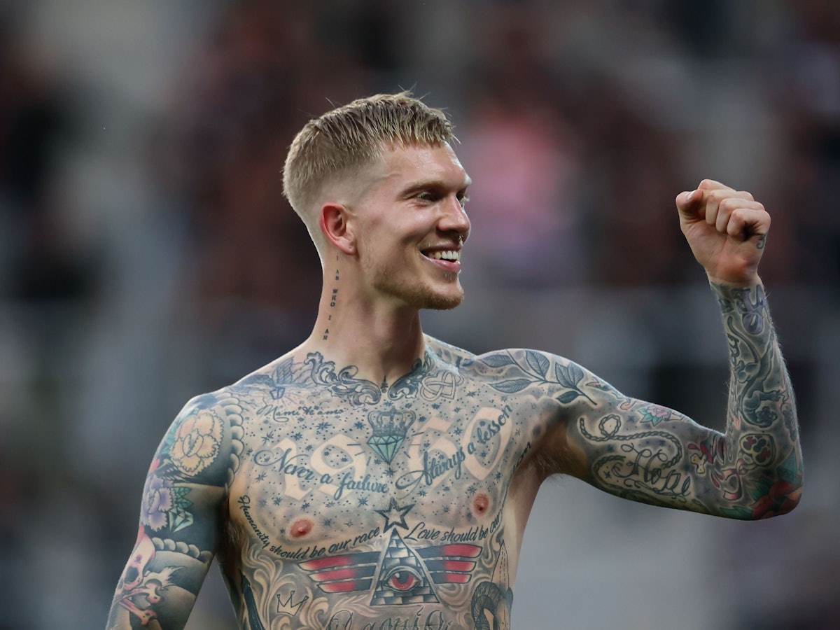 Simon Makienok jubelt mit erhobener Faust und nacktem Oberkörper.