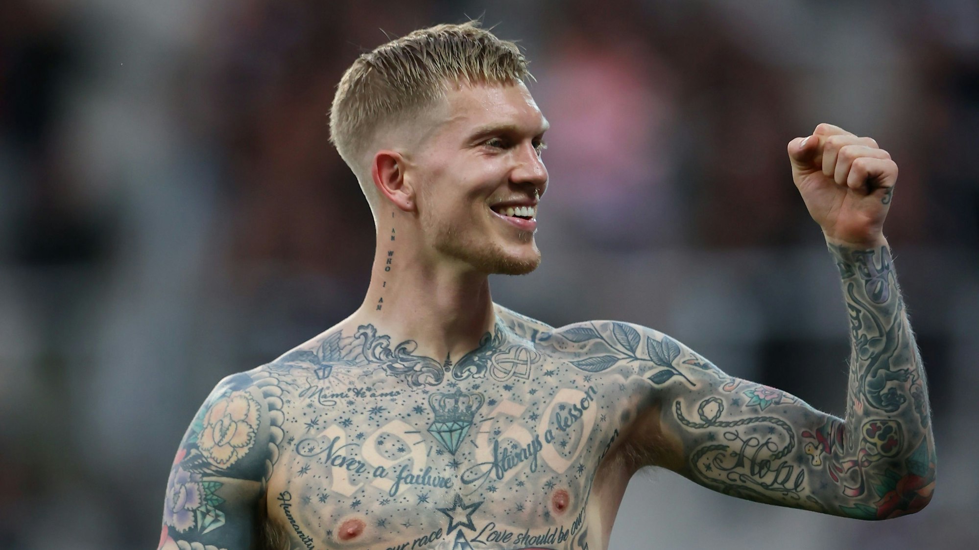 Simon Makienok jubelt mit erhobener Faust und nacktem Oberkörper.