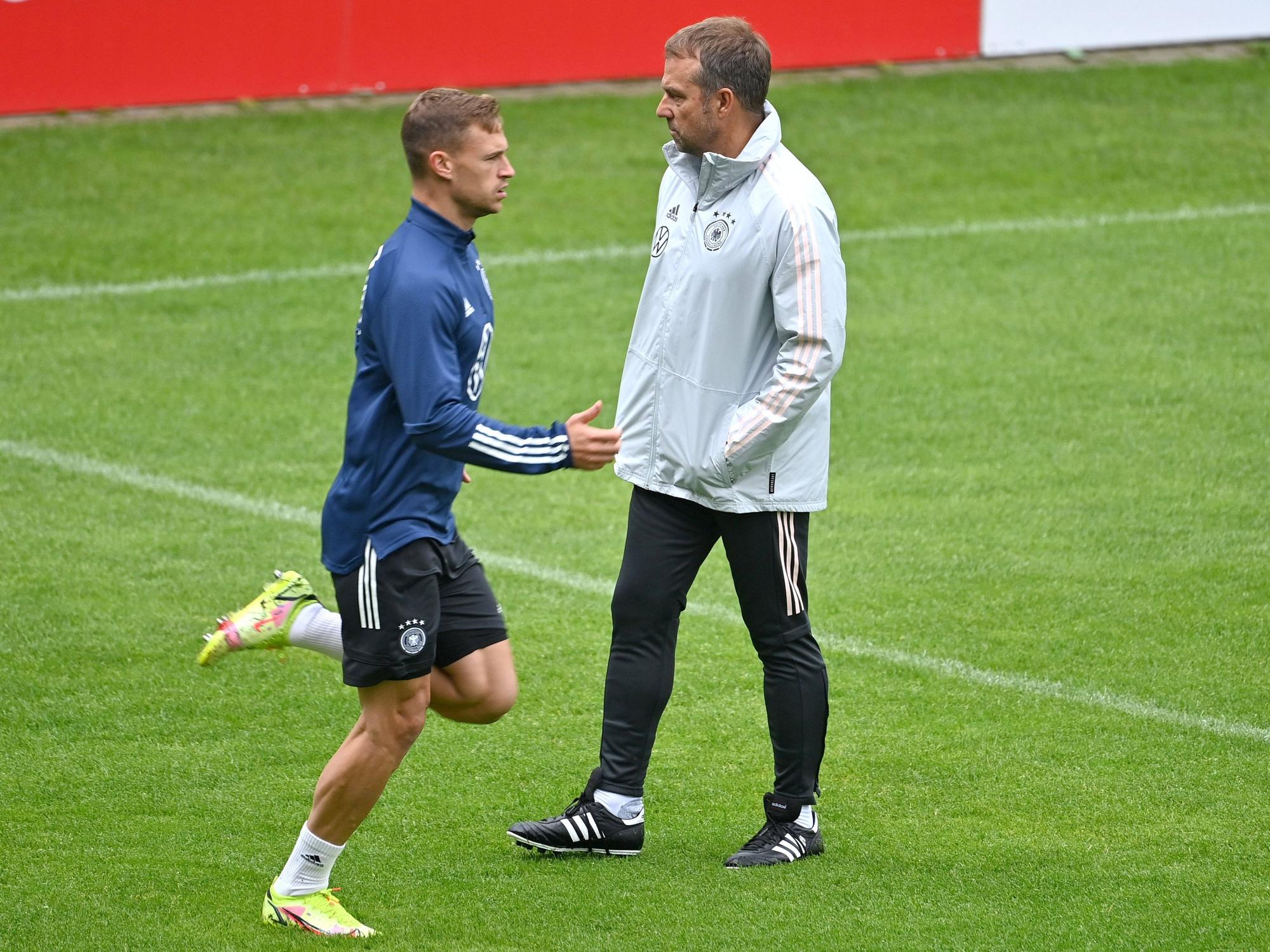 Joshua Kimmich trainiert und wird von Hansi Flick beobachtet.
