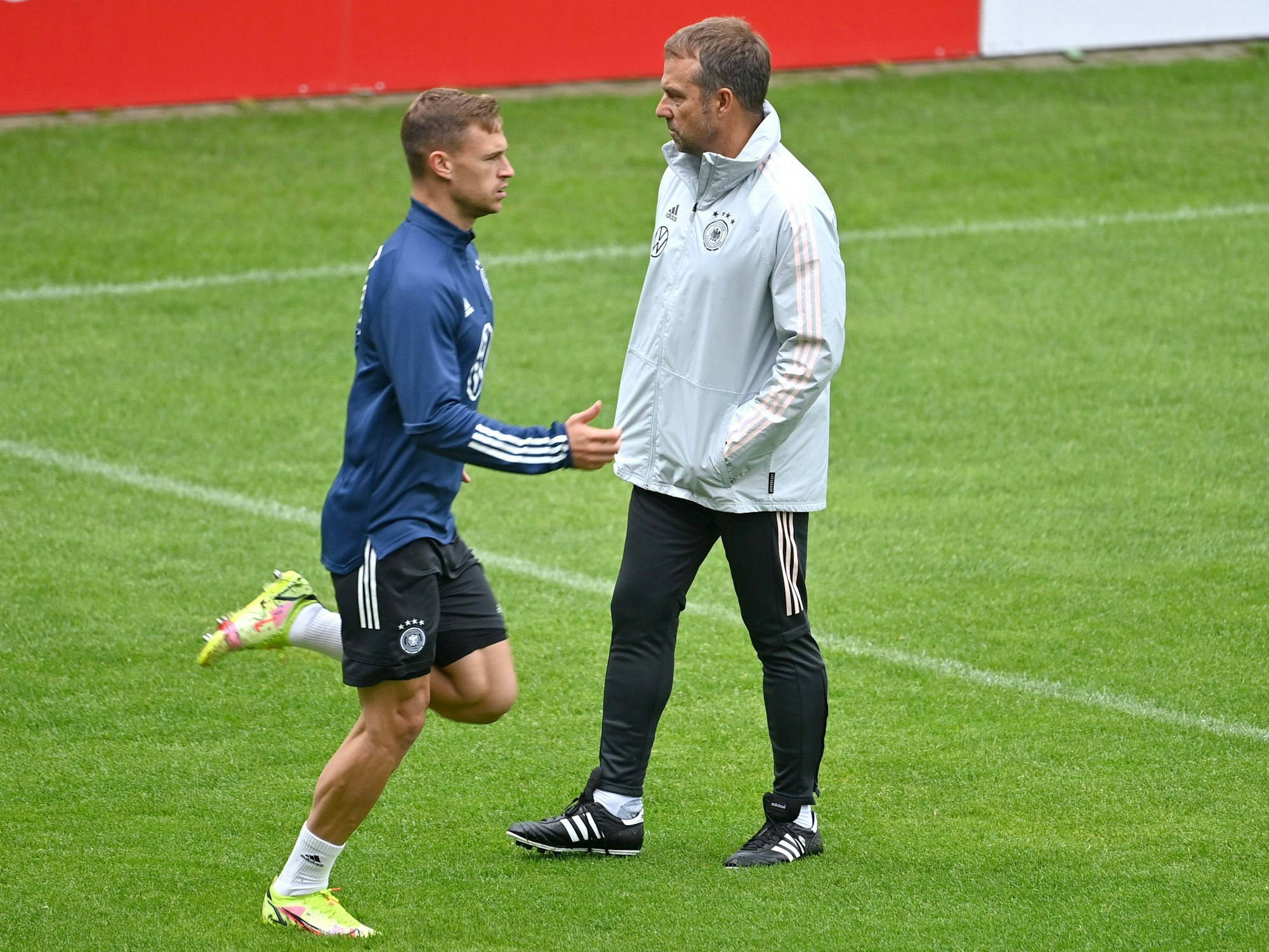 Joshua Kimmich trainiert und wird von Hansi Flick beobachtet.