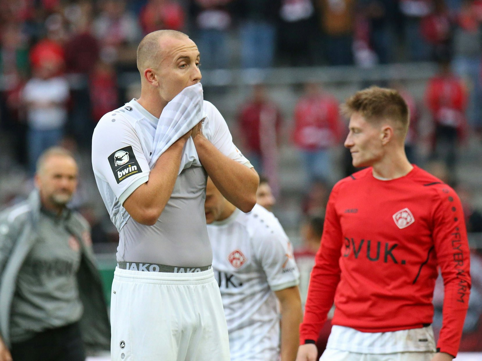 Tobias Kraulich von den Würzburger Kickers wischt sich mit seinem Trikot den Mund ab.