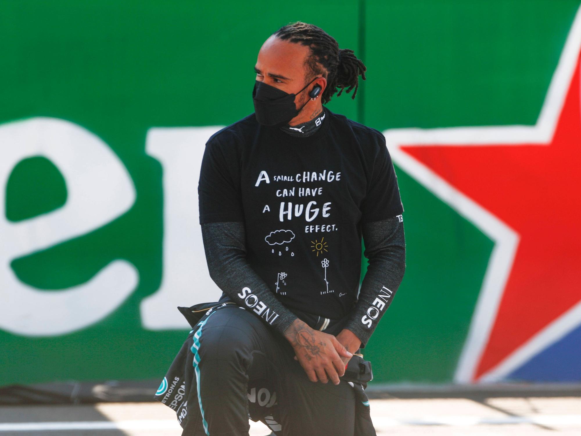 Lewis Hamilton trägt eine Maske und kniet.