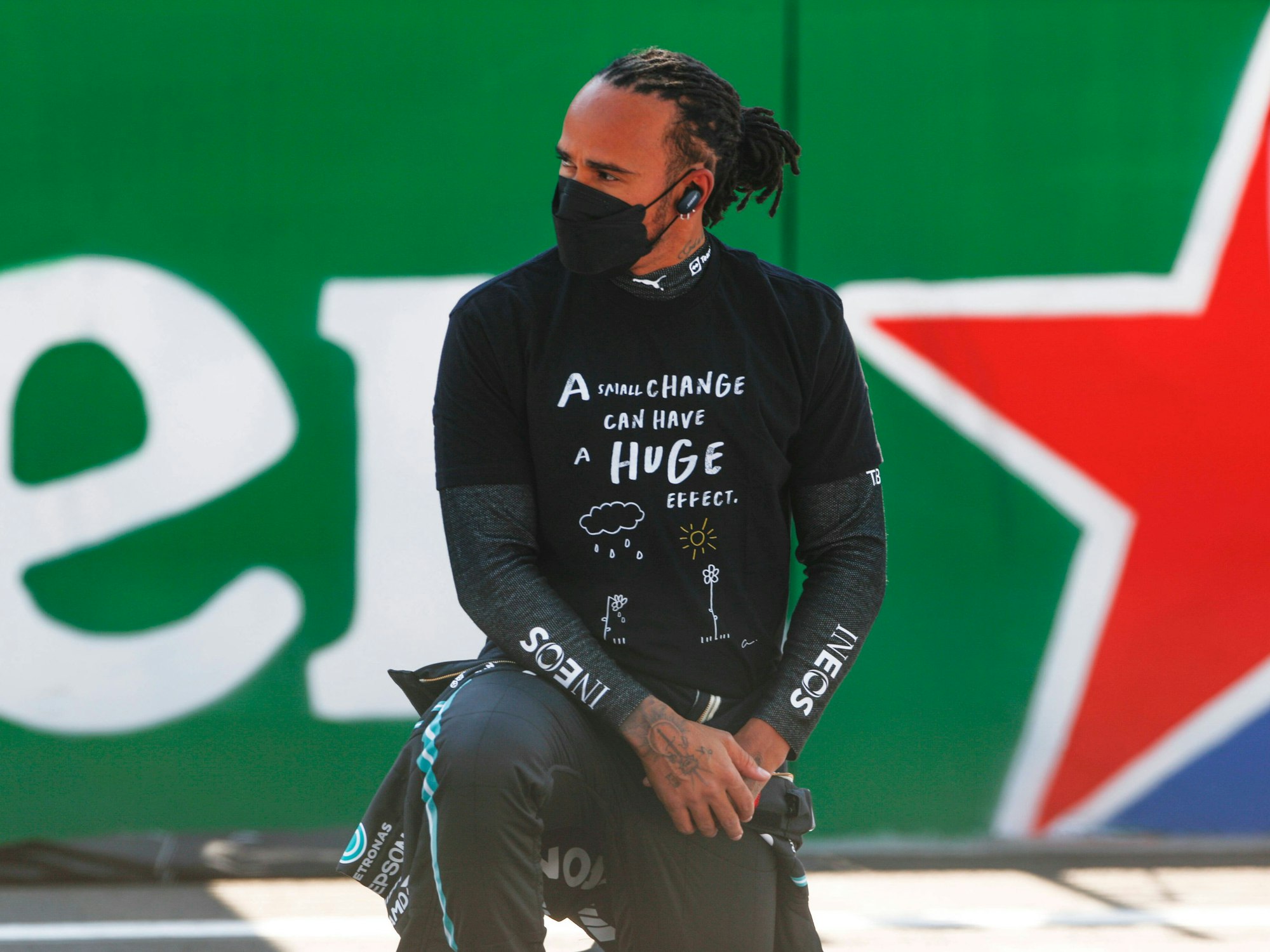 Lewis Hamilton trägt eine Maske und kniet.