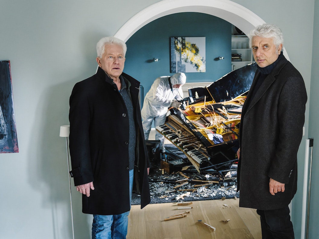 Ivo Batic (Miroslav Nemec, l) und Franz Leitmayr (Udo Wachtveitl) fragen sich, wer den Flügel zerstört haben könnte in einer Szene aus „Tatort: Dreams“. Der Krimi wird am 07.11.2021 um 20:15 Uhr im Ersten ausgestrahlt.