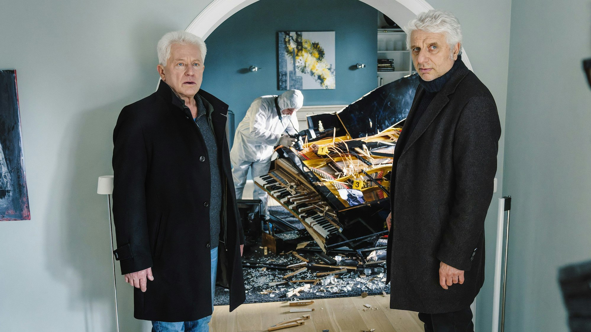 Ivo Batic (Miroslav Nemec, l) und Franz Leitmayr (Udo Wachtveitl) fragen sich, wer den Flügel zerstört haben könnte in einer Szene aus „Tatort: Dreams“. Der Krimi wird am 07.11.2021 um 20:15 Uhr im Ersten ausgestrahlt.