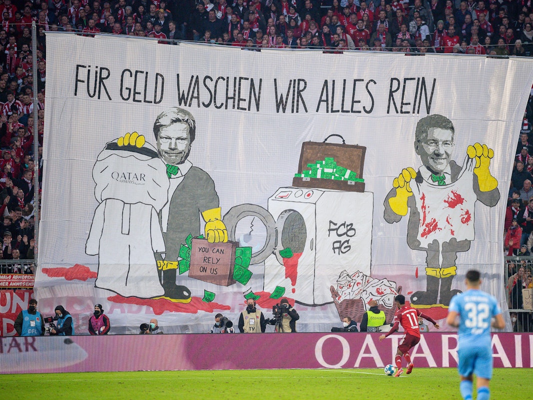 Mit einem Transparent „Für Geld waschen wir alles rein“ protestieren Fans von Bayern München gegen die Geschäftsbeziehungen des Rekordmeisters mit Katar.