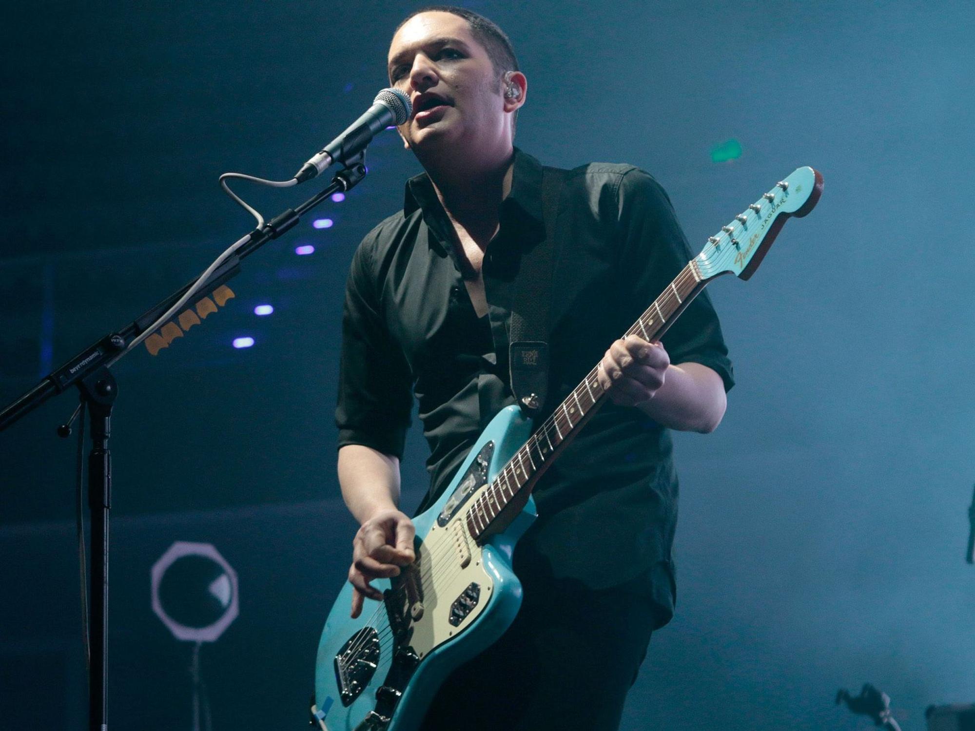 Brian Molko spielt Gitarre auf der Bühne.