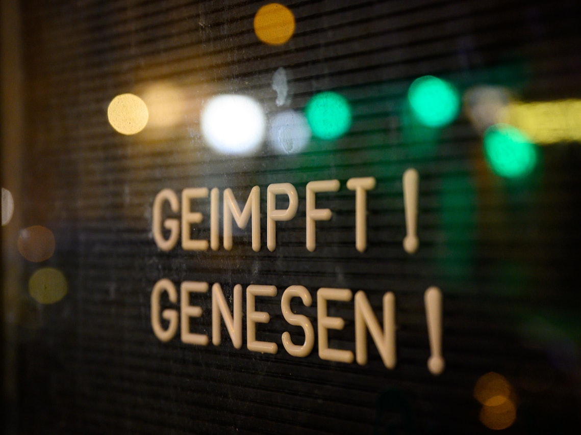 Auf dem Symbolfoto (aufgenommen am 6. November 2021) ist ein Schaukasten zu sehen, in welchem ein Schild mit der Aufschrift „Geimpft! Genesen!“ steht.