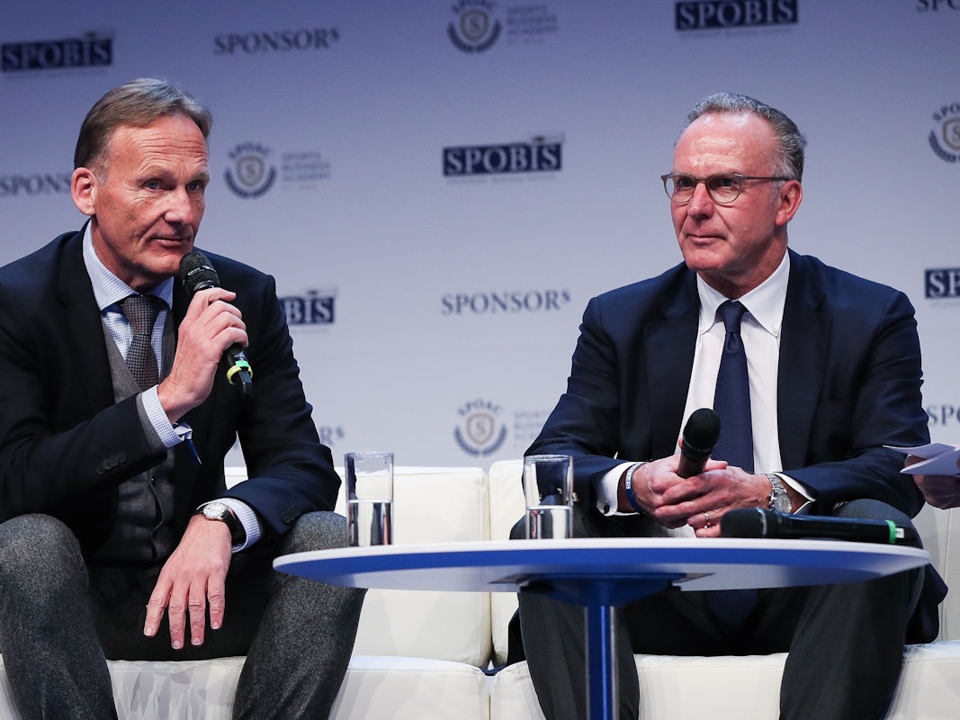 Karl-Heinz Rummenigge (r.) und Hans-Joachim Watzke sitzen nebeneinander auf der Bühne.