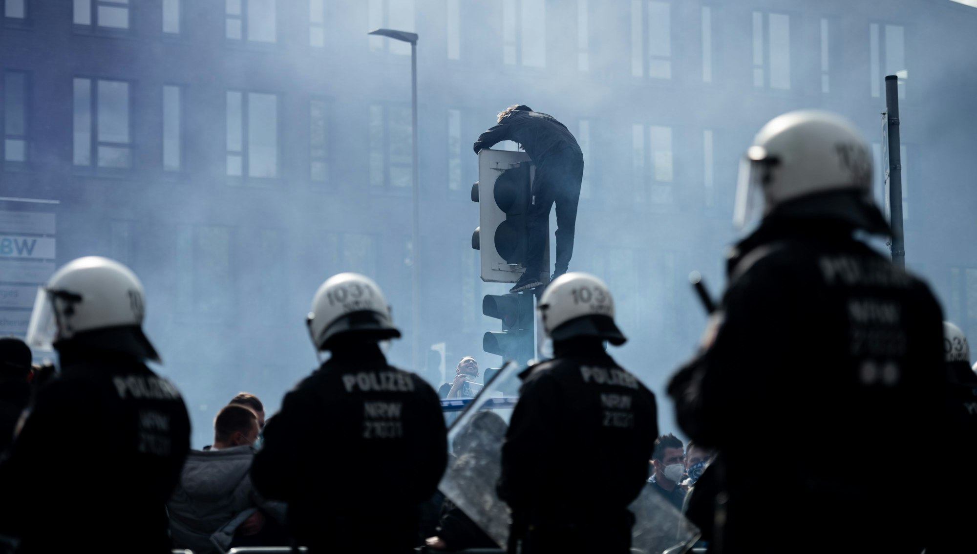 Bochum-Fans feiern am 23. Mai 2021 auf der Castroperstraße vor dem Vonovia Ruhrstadion hinter einer Polizeikette. Der VfL Bochum ist in die 1. Bundesliga aufgestiegen.