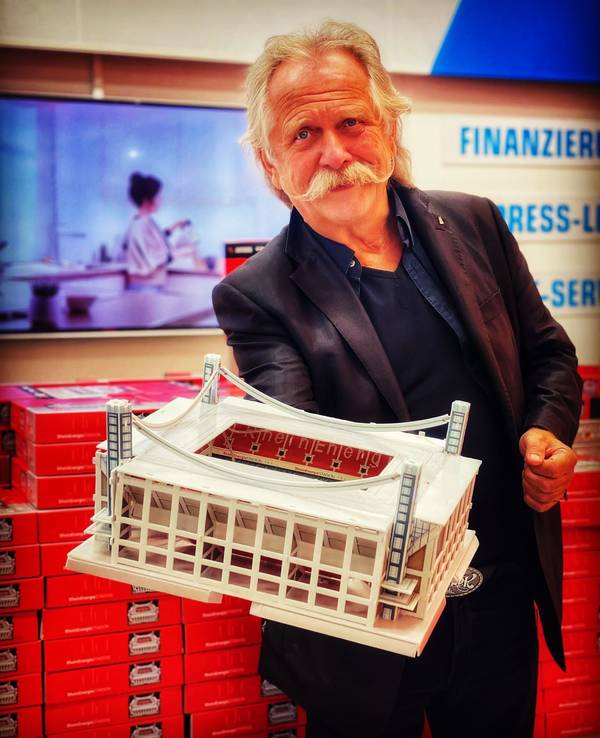 Henning Krautmacher hält eine Stadion-Miniatur hoch