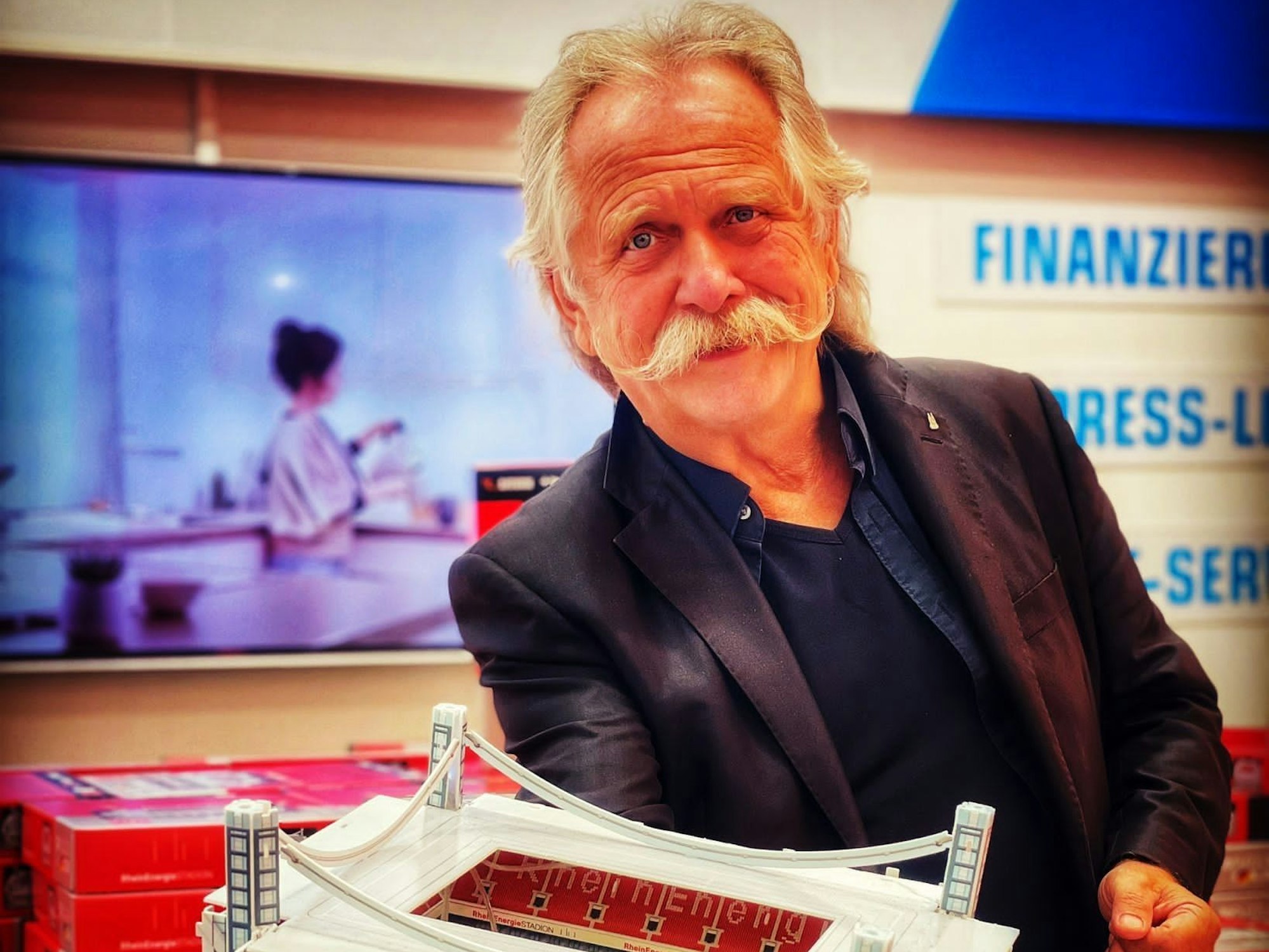 Henning Krautmacher hält eine Stadion-Miniatur hoch