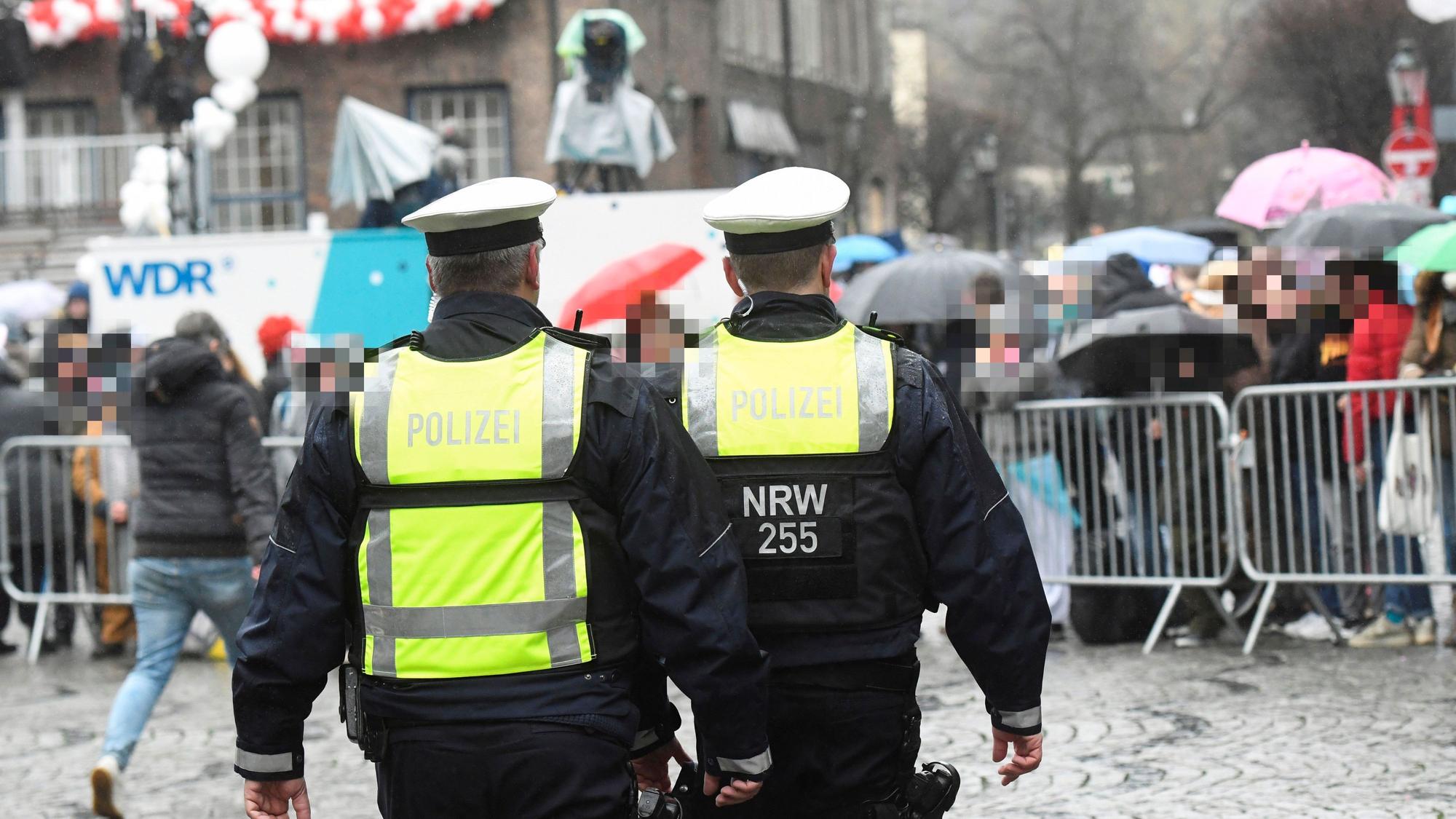 Polizisten gehen am 24. Februar 2020 über die abgesperrte Strecke beim Rosenmontagszug in Düsseldorf.