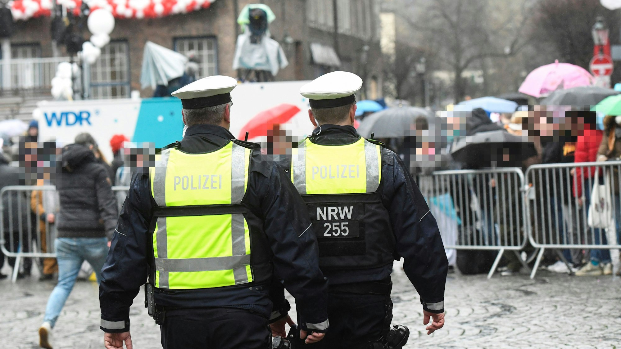 Polizisten gehen am 24. Februar 2020 über die abgesperrte Strecke beim Rosenmontagszug in Düsseldorf.