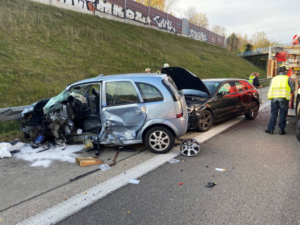Zwei stark beschädigte Autos stehen auf dem Seitenstreifen einer Autobahn.