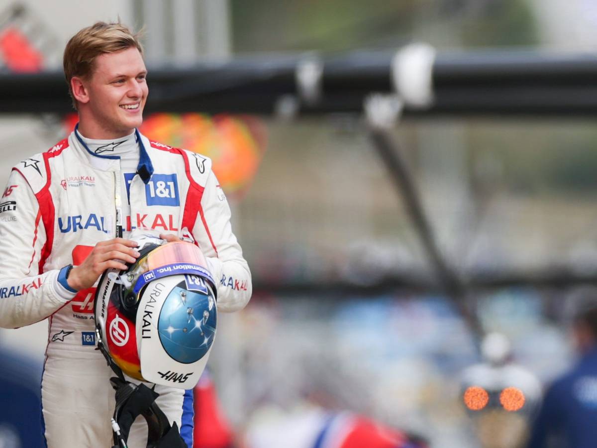 Mick Schumacher geht lachend durch die Boxengasse der Formel 1.