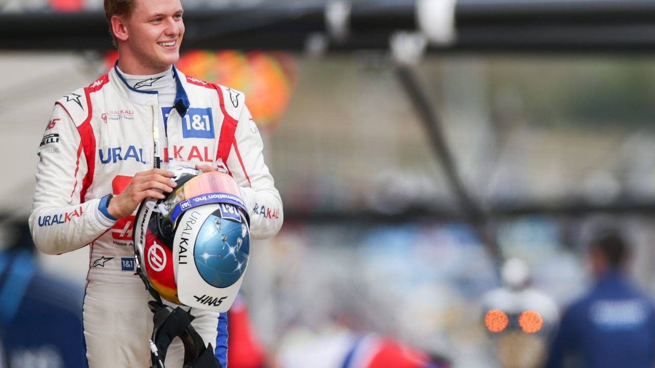 Mick Schumacher geht lachend durch die Boxengasse der Formel 1.