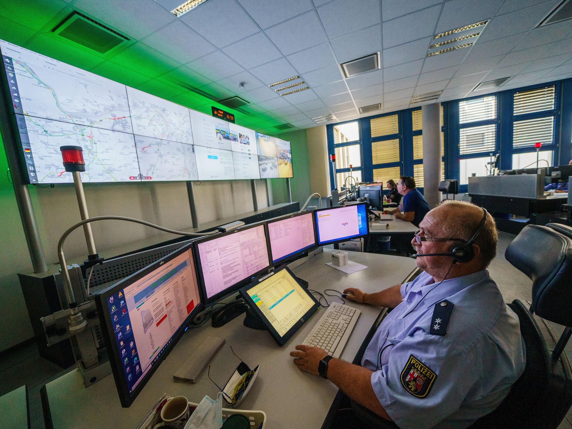 Ein Polizeibeamter sitzt in der Führungszentrale