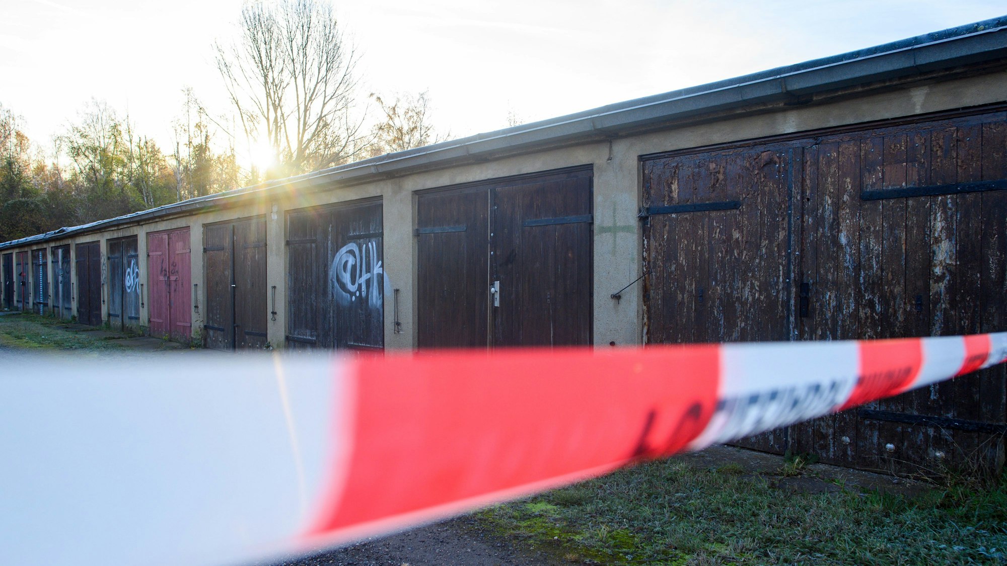 Absperrband der Polizei sperrt einen Teil eines Garagenkomplexes ab. Dort war die Leiche von einer 14-Jähriger gefunden worden die seit Tagen als vermisst galt. +++ dpa-Bildfunk +++
