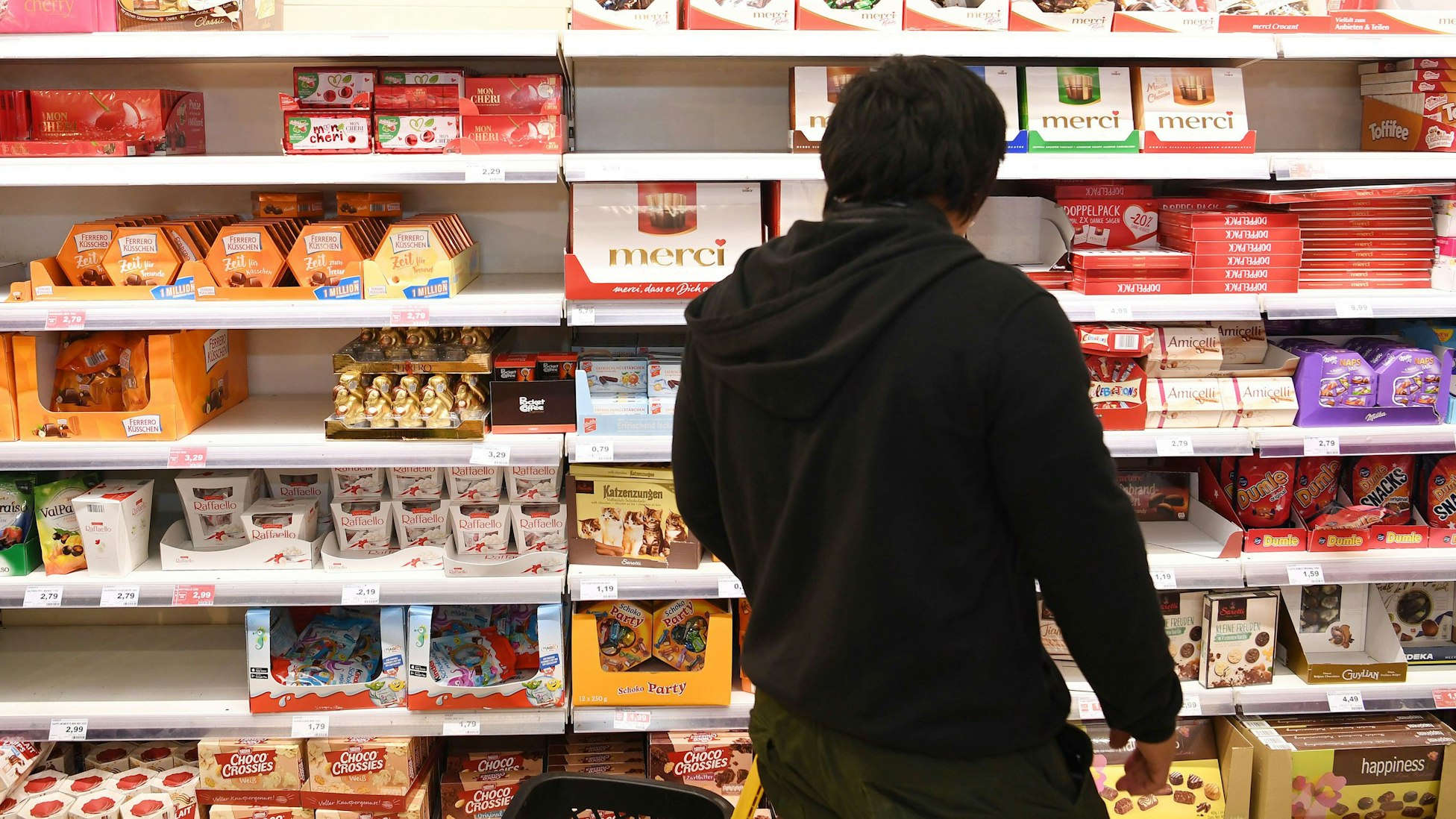 Auf dem Symbolfoto (aufgenommen am 29. Oktober 2018) ist ein Mann vor einem Regal voller Süßigkeiten im Supermarkt zu sehen.