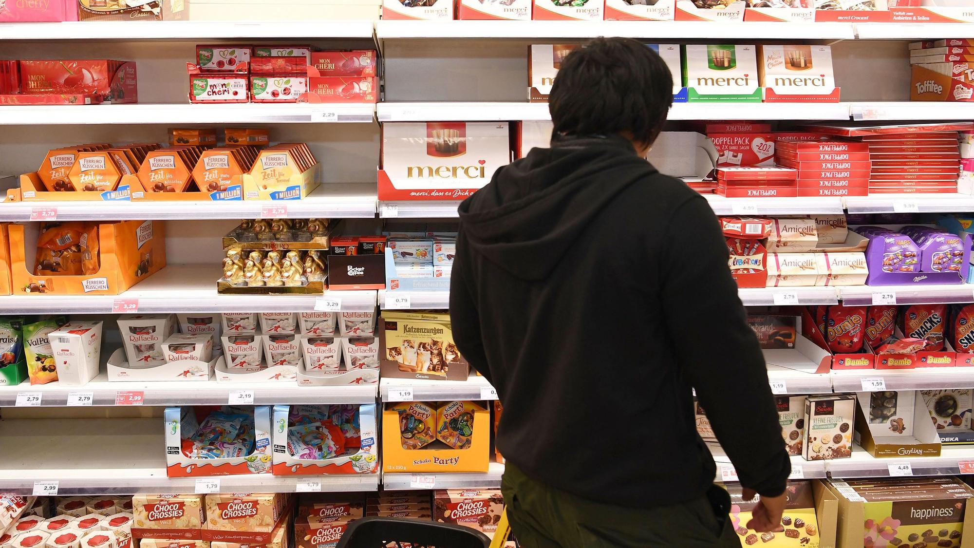 Auf dem Symbolfoto (aufgenommen am 29. Oktober 2018) ist ein Mann vor einem Regal voller Süßigkeiten im Supermarkt zu sehen.