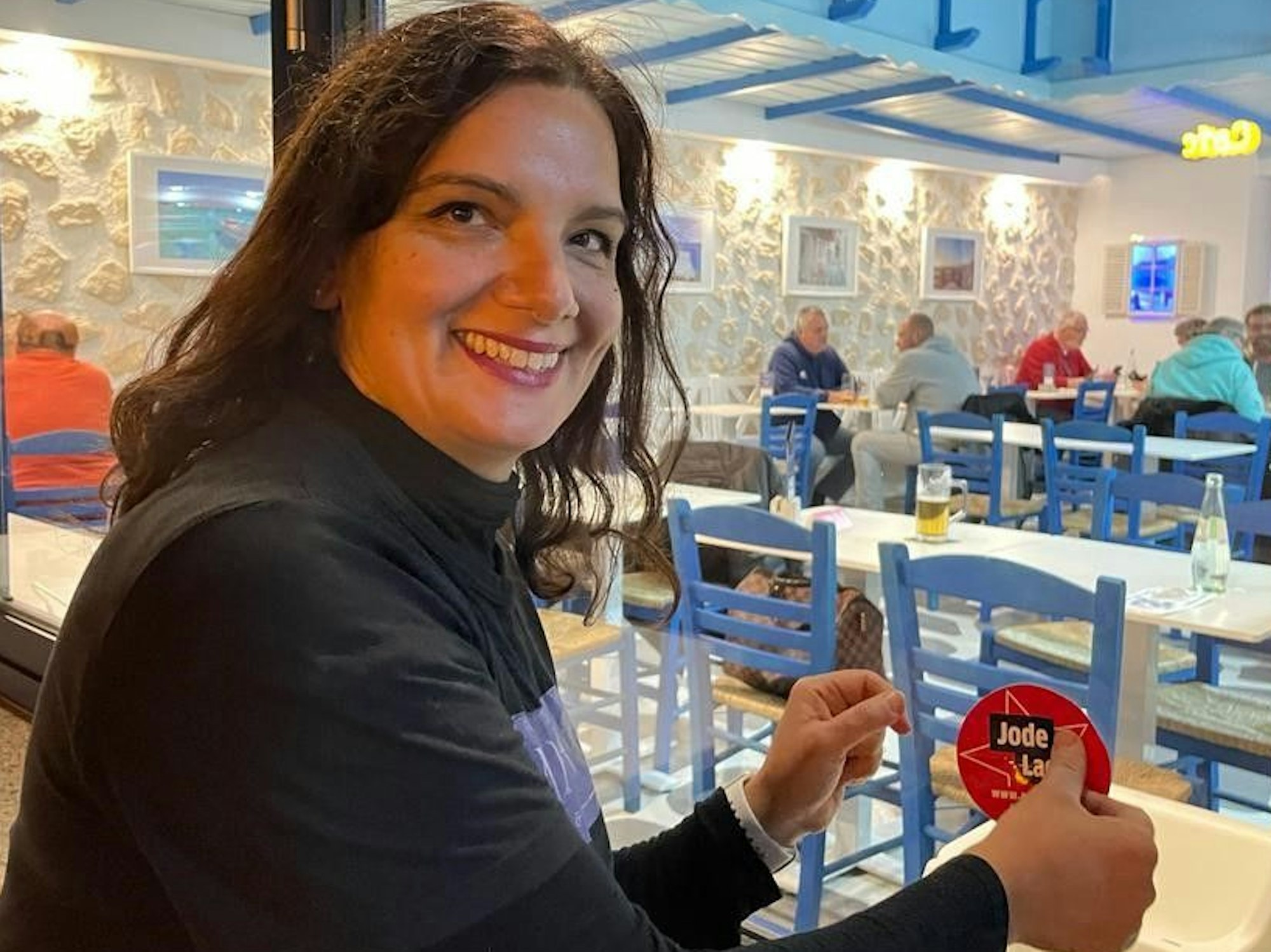 Aphroditi bringt den Aufkleber an.