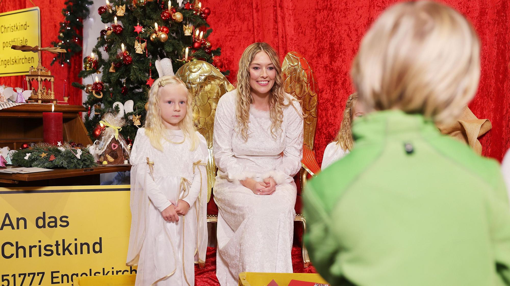 Die Darstellerin des Christkindes (M) nimmt Wunschzettel von Kindern entgegen