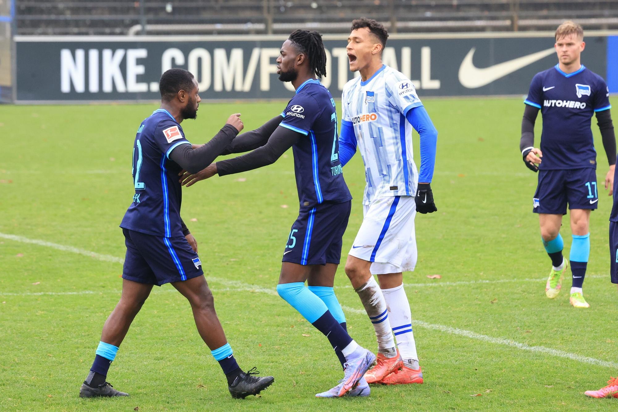Die Hertha-Spieler Deyovaisio Zeefuik und Davie Selke liefern sich im Training ein Wortgewecht, Mitspieler Jordan Torunarigha versucht zu schilchten