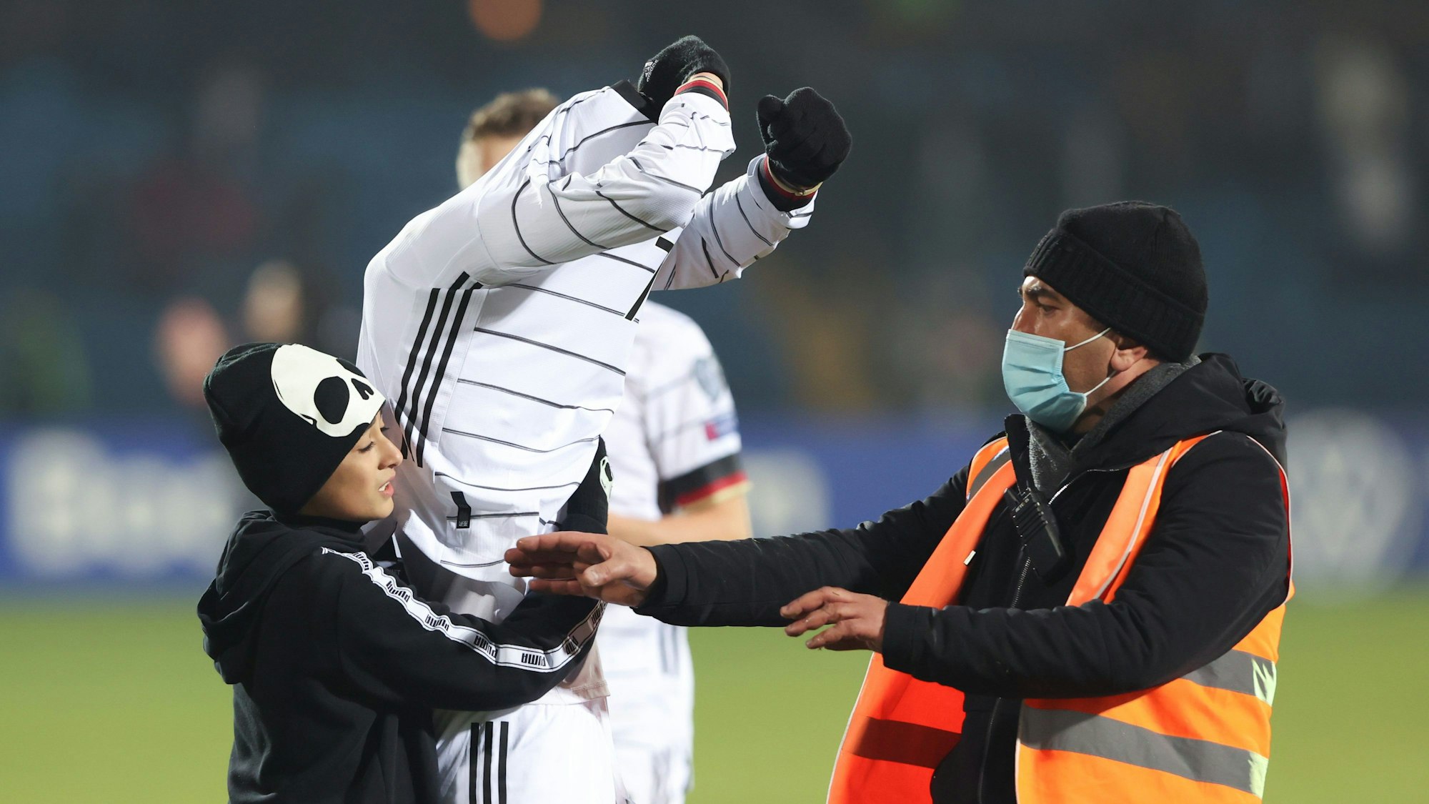 Kai Havertz zieht sein Trikot aus und gibt es einem Fan.