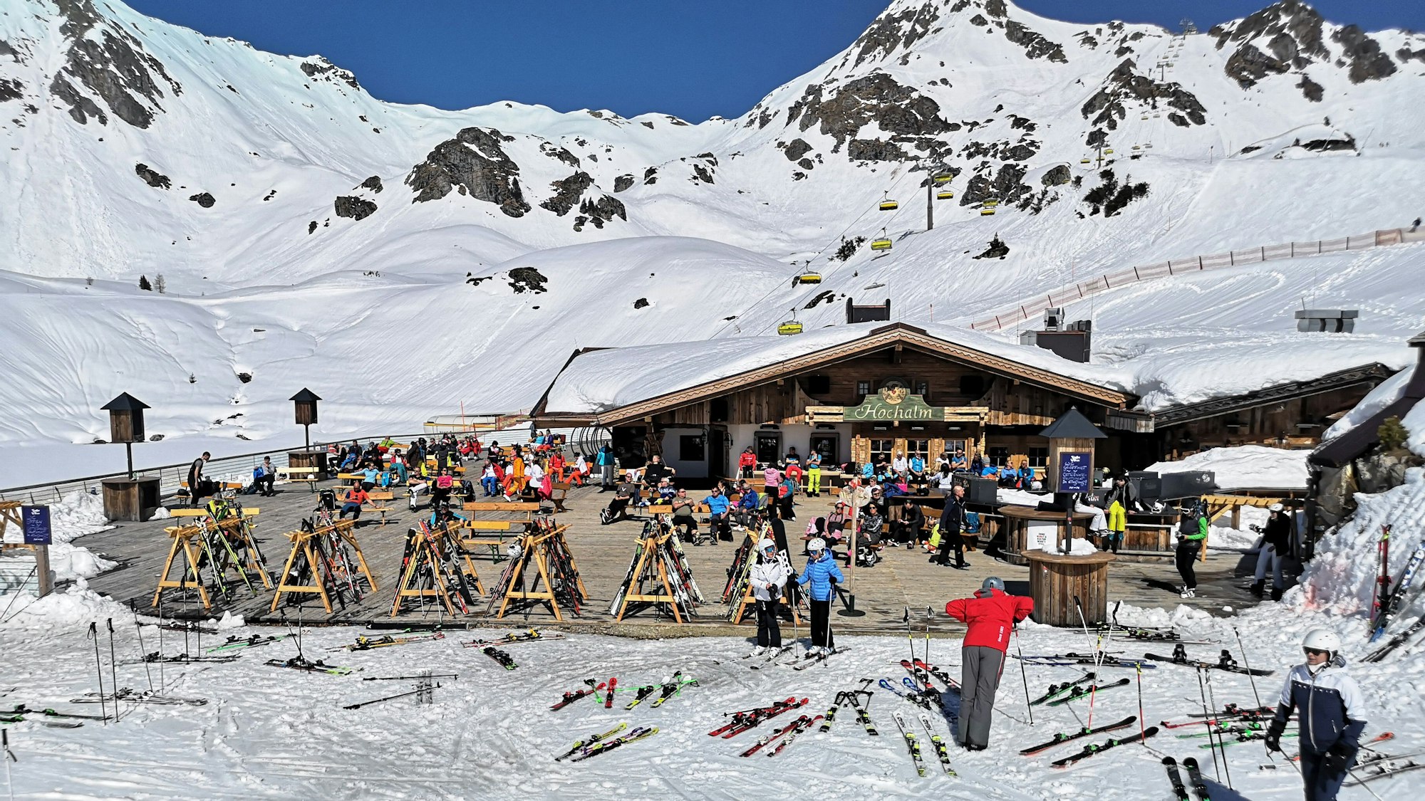 Auf dem Foto (aufgenommen am 31. März 2021) sieht man Skifahrer in Österreich auf der Terrasse einer geschlossenen Skihütte sitzen.