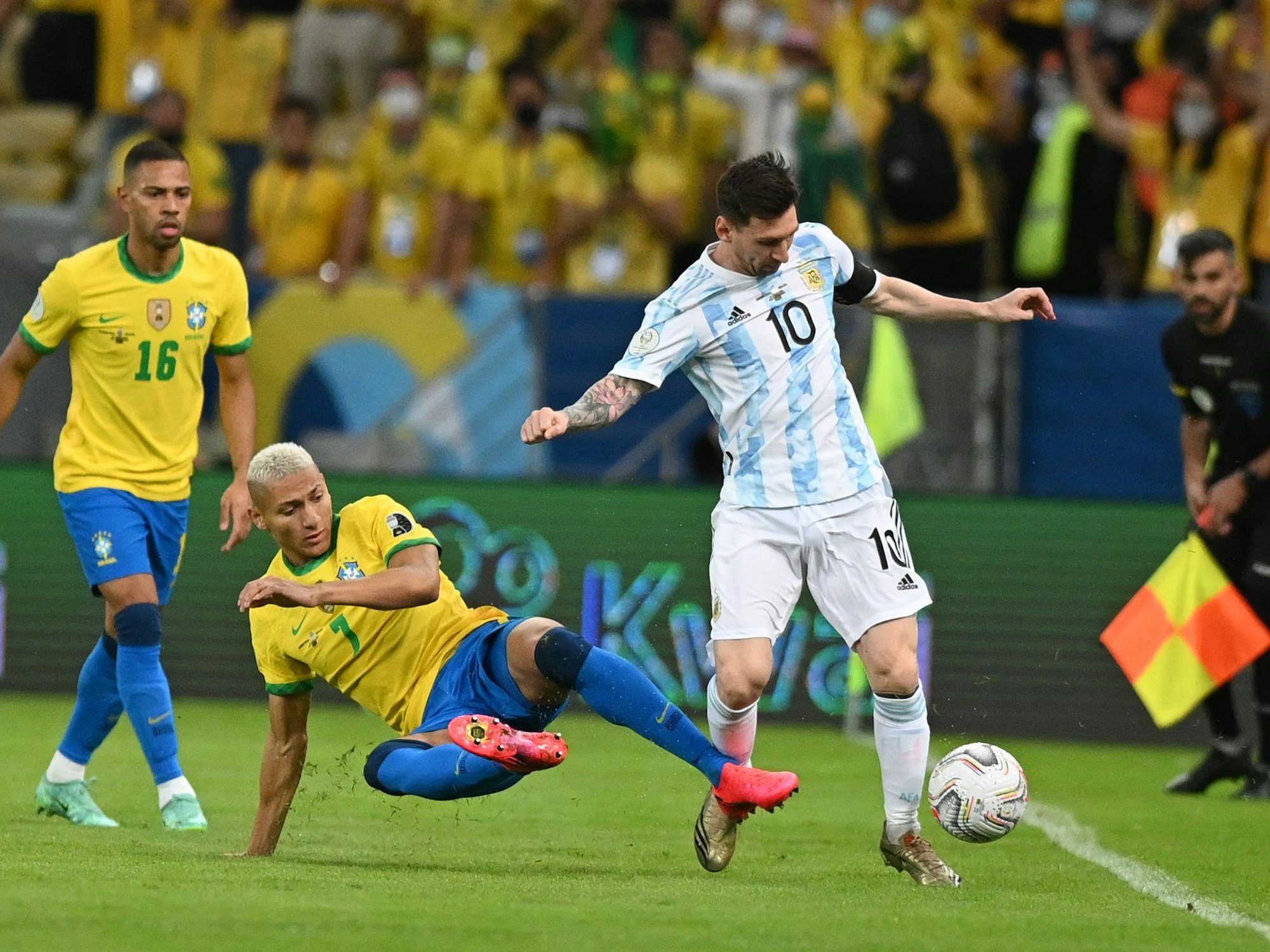 Richarlison aus Brasilien versucht Lionel Messi aus Argentinien zu stoppen, während Renan Lodi zuschaut.