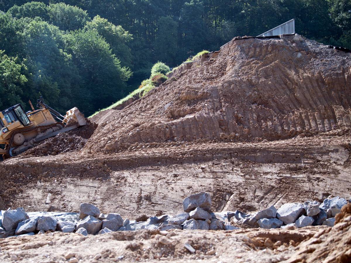 Eine Planierraupe arbeitet an dem vom Hochwasser beschädigten Damm der Steinbachtalsperre.
