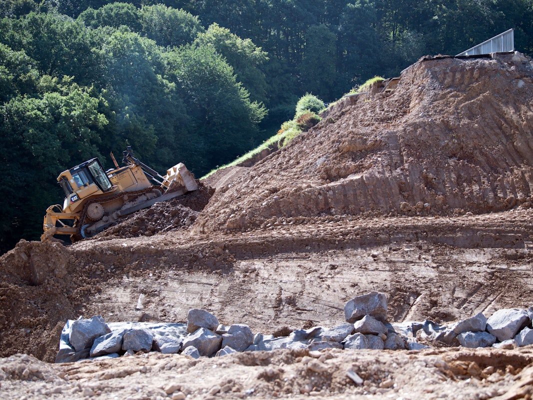 Eine Planierraupe arbeitet an dem vom Hochwasser beschädigten Damm der Steinbachtalsperre.