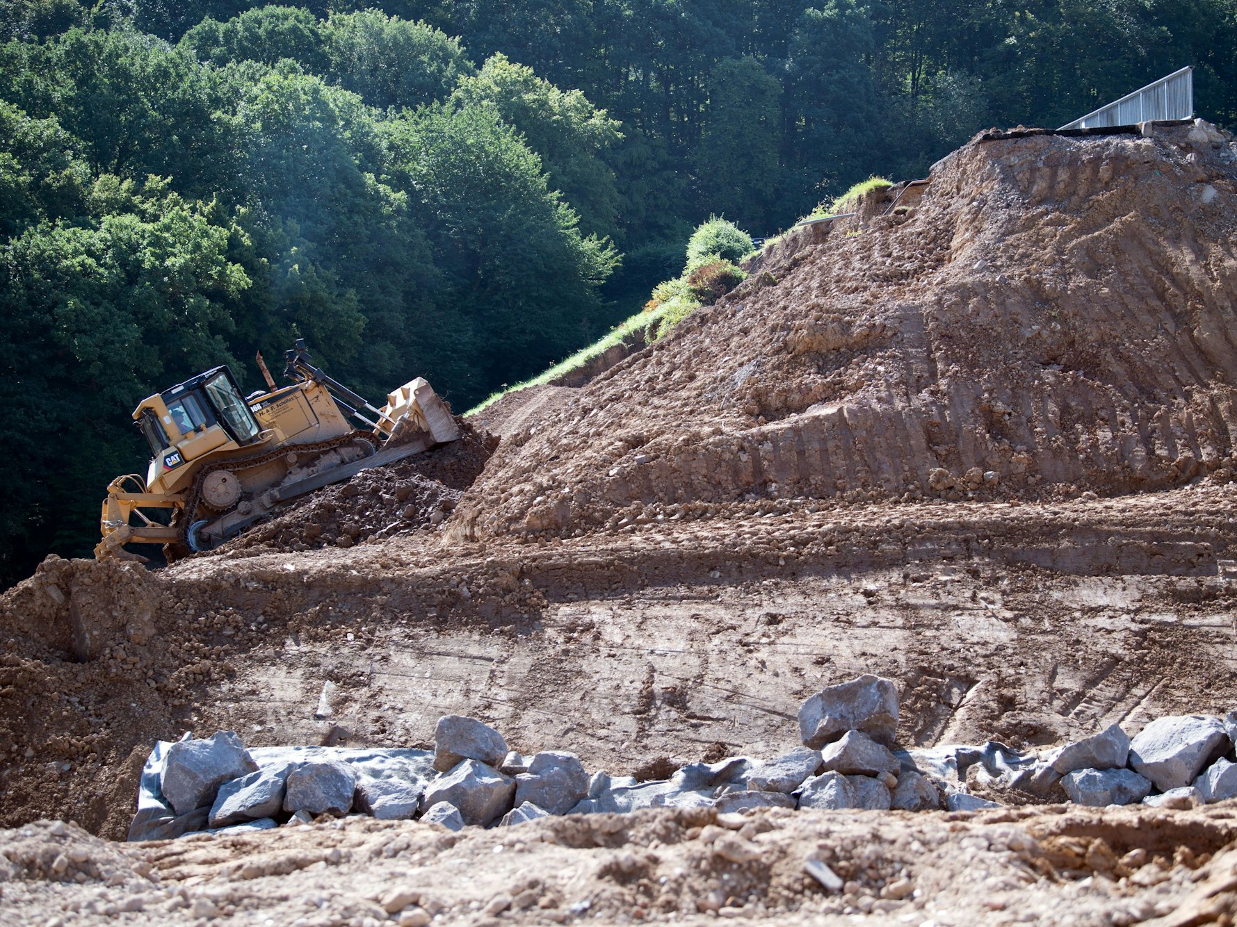 Eine Planierraupe arbeitet an dem vom Hochwasser beschädigten Damm der Steinbachtalsperre.