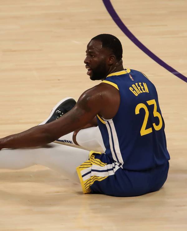Draymond Green sitzt auf dem Boden des Spielfelds.