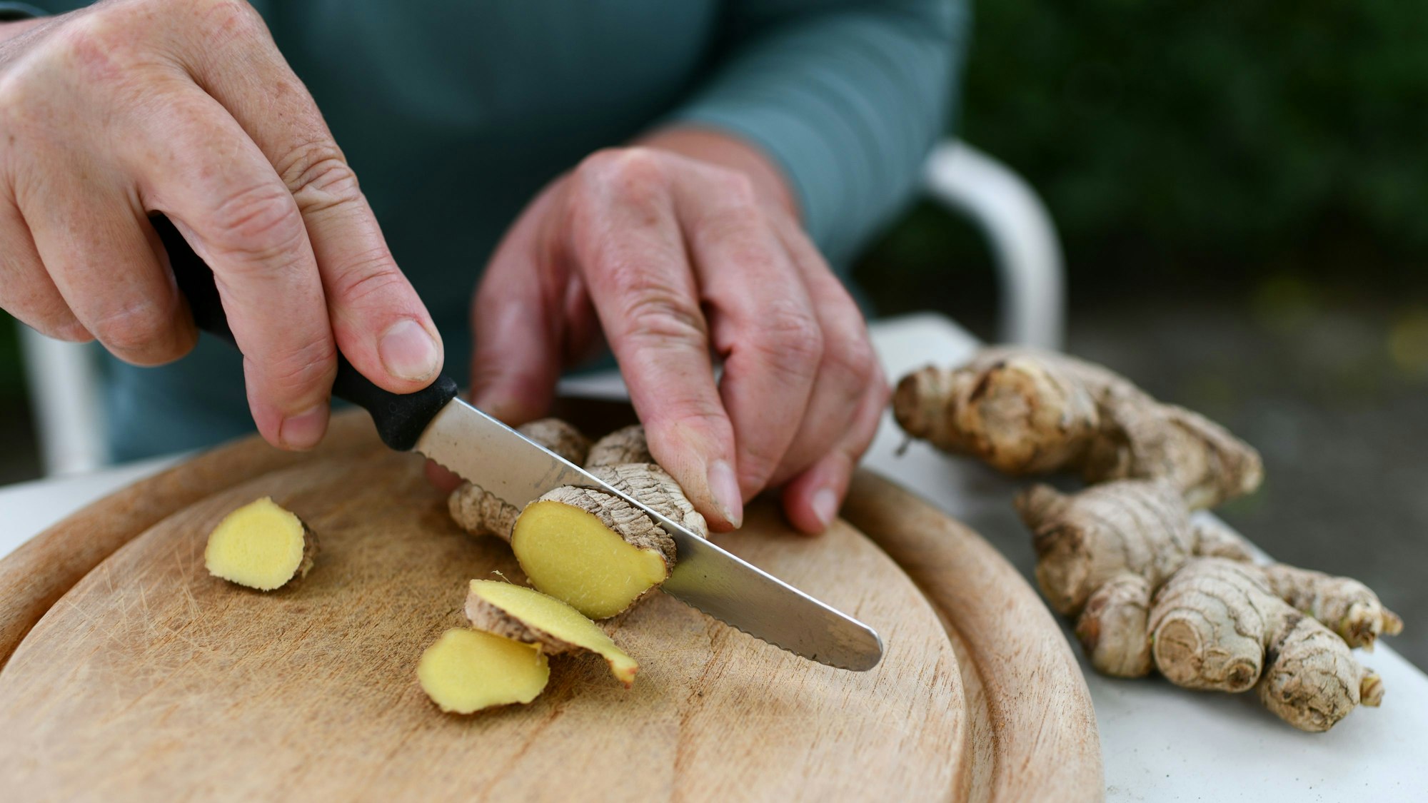Ingwer-Shots sind heutzutage stark im Trend. Auf dem Foto (aufgenommen am 21. Juni 2018) ist zu sehen, wie jemand eine Ingwer-Knolle schneidet.