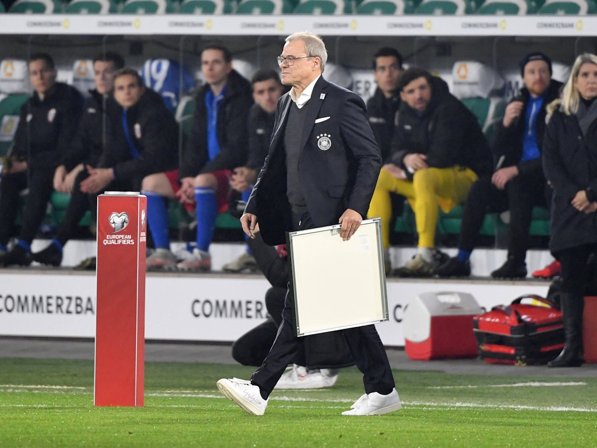 Peter Peters geht mit einer Urkunde in der Hand auf den Platz.