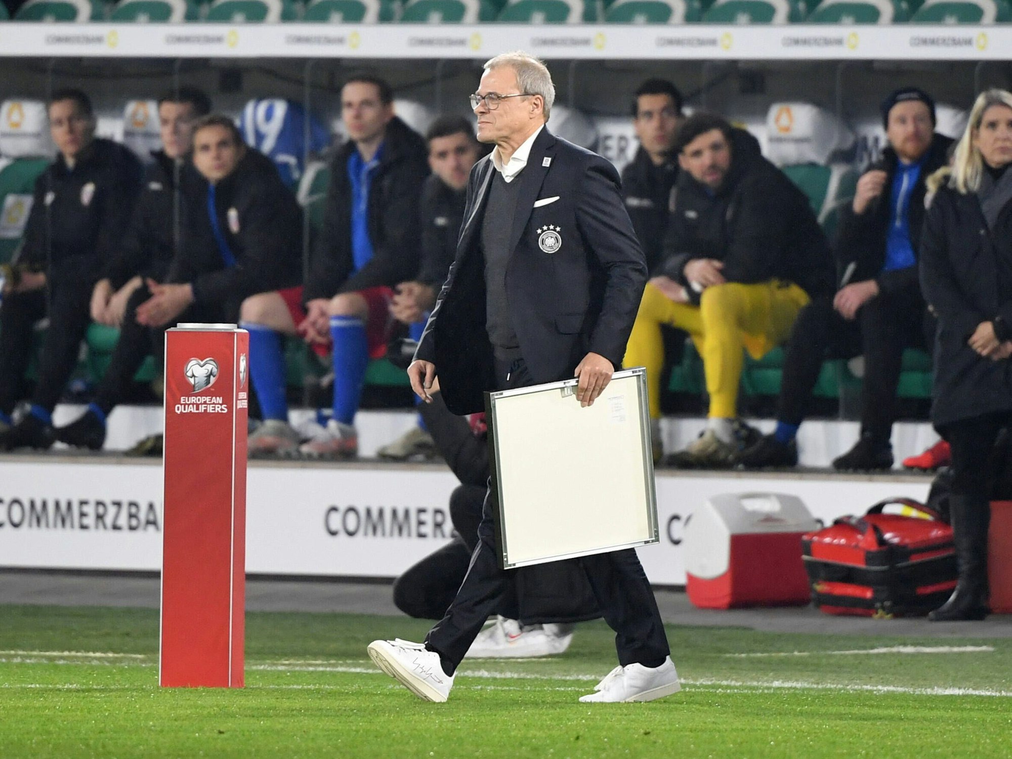 Peter Peters geht mit einer Urkunde in der Hand auf den Platz.