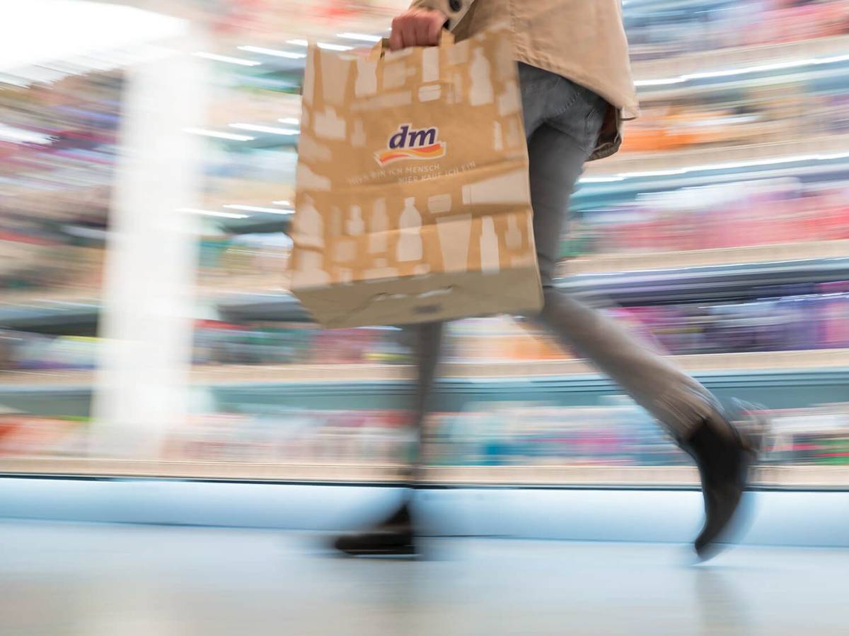 Auf dem Symbolfoto (aufgenommen am 11. November 2021) sieht man eine Frau mit dm-Tragetasche durch das Geschäft gehen.