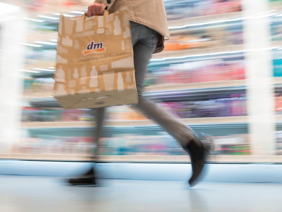 Auf dem Symbolfoto (aufgenommen am 11. November 2021) sieht man eine Frau mit dm-Tragetasche durch das Geschäft gehen.