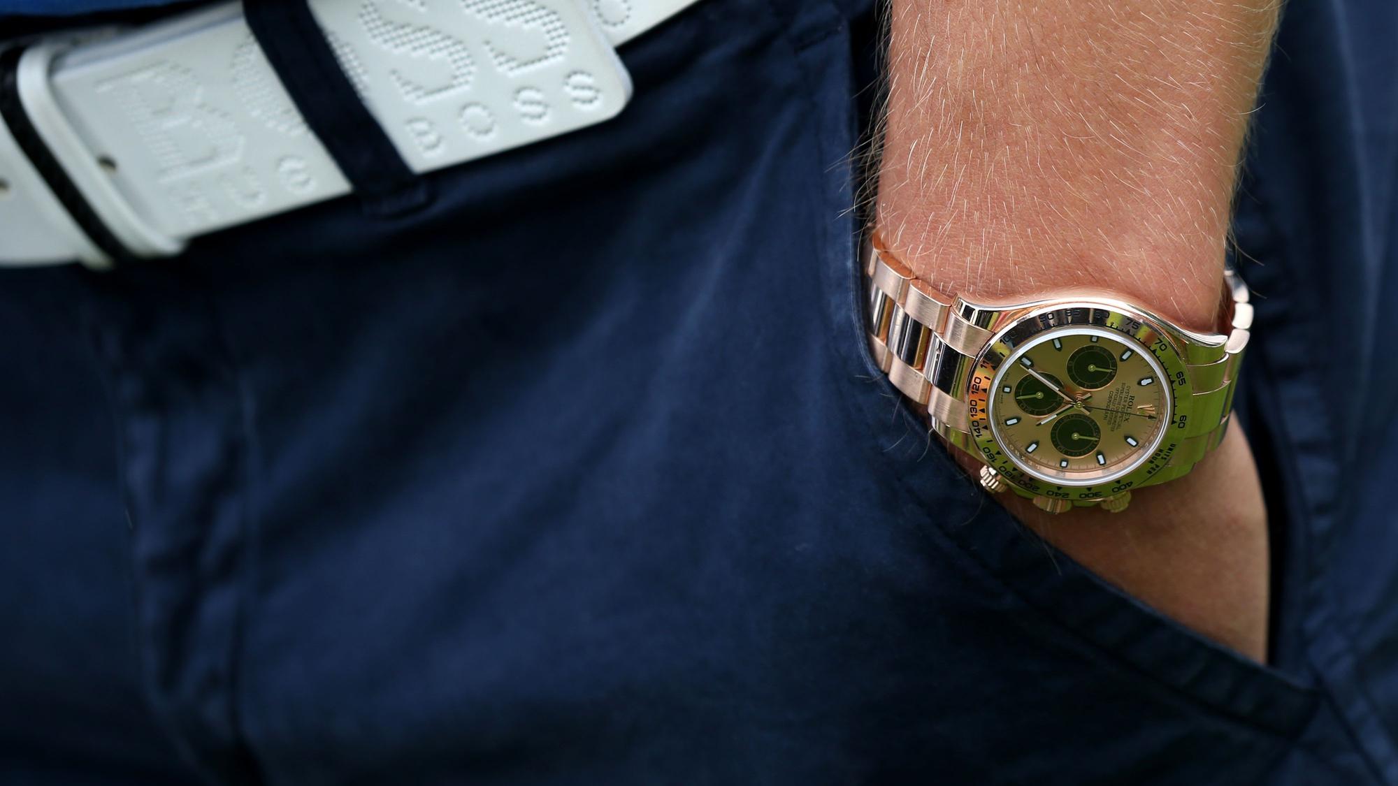 Ein Mann trägt eine Rolex-Uhr.