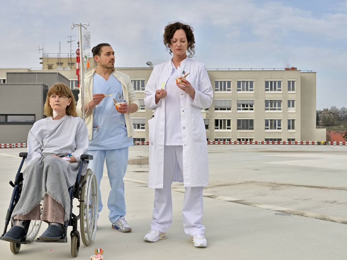 Carolin Mellau (Natalia Wörner, r) und der Pfleger Mirko (Johannes Klaußner) sind mit Madame Laurent (Ursula Andermatt) auf dem Dach der Klinik und essen Eis in einer Szene des Films „Die Welt steht still“ (undatierte Filmszene).