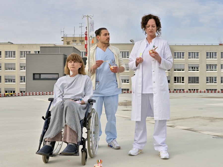 Carolin Mellau (Natalia Wörner, r) und der Pfleger Mirko (Johannes Klaußner) sind mit Madame Laurent (Ursula Andermatt) auf dem Dach der Klinik und essen Eis in einer Szene des Films „Die Welt steht still“ (undatierte Filmszene).