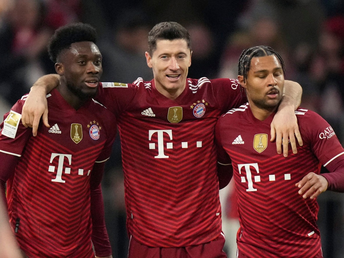 Bayern's Robert Lewandowski jubelt mit Alphonso Davies (l.) und Serge Gnabry (r.).