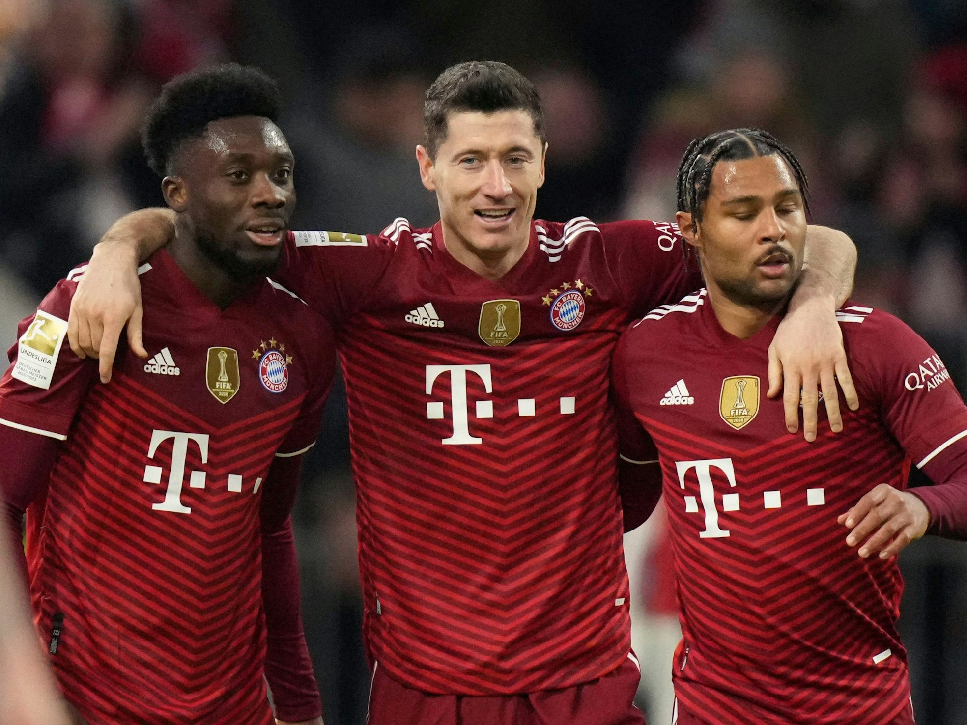 Bayern's Robert Lewandowski jubelt mit Alphonso Davies (l.) und Serge Gnabry (r.).